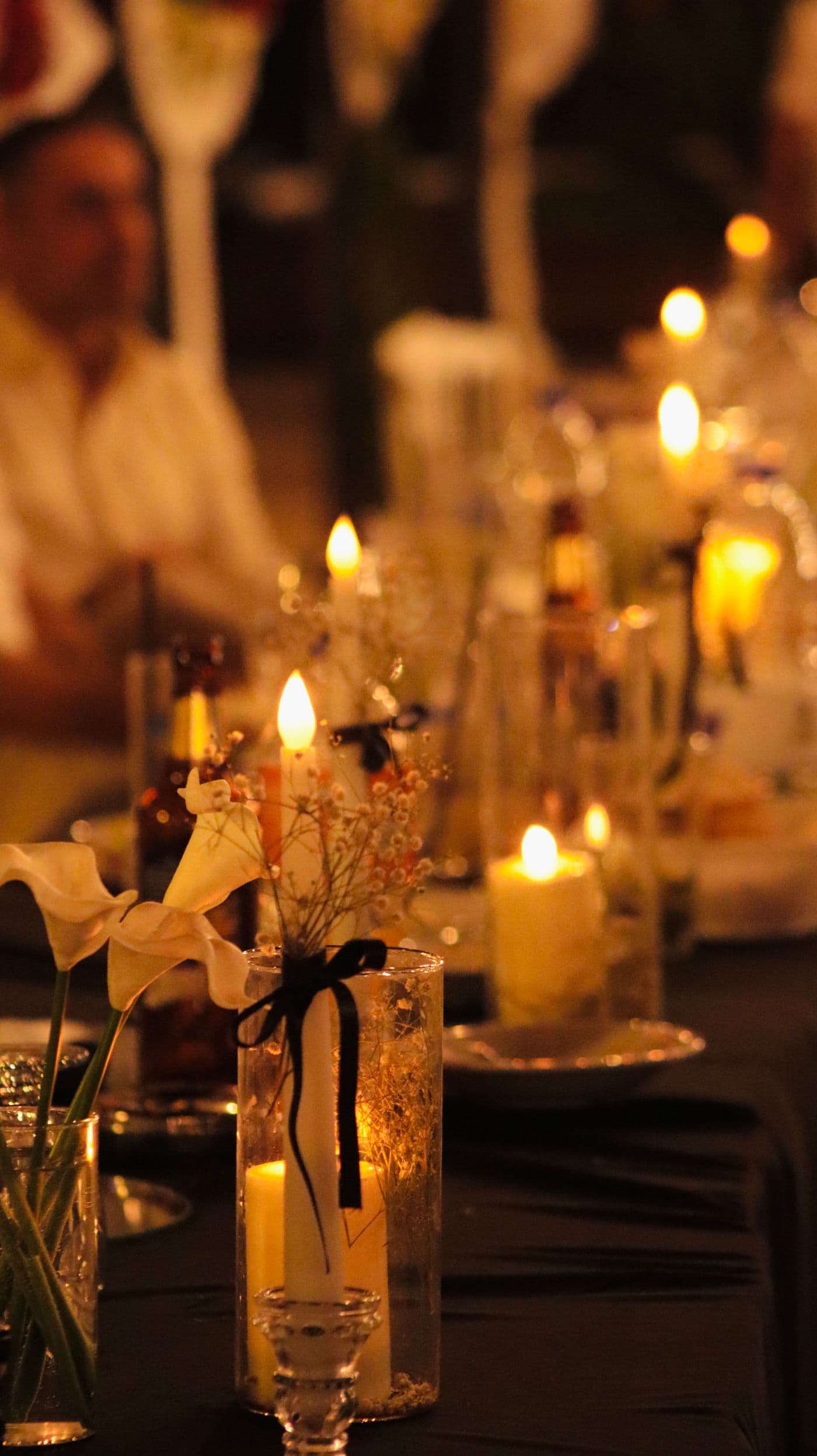 Candlelit banquet table with white calla lilies and warm golden light