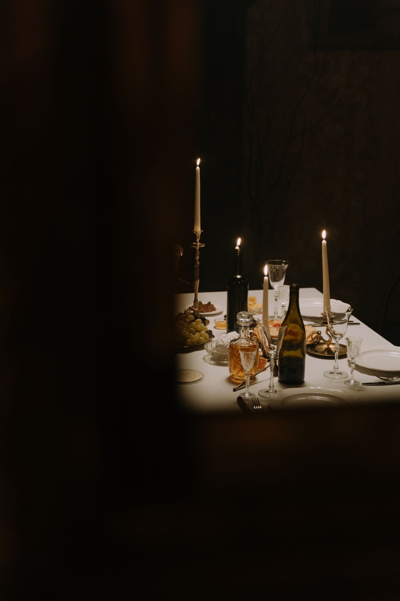 Candlelit dinner table with tall tapers and crystal glassware